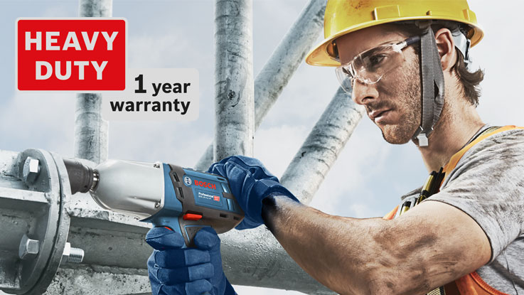 คนงานที่สวมหมวกกันน็อคกำลังใช้สว่านไร้สายสีน้ำเงินของ Bosch Professional.