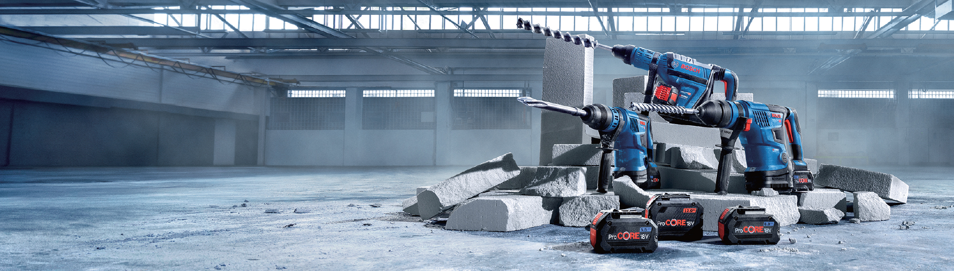 เครื่องมือ Bosch Professional สีน้ำเงินสองชิ้นอยู่ข้างชิ้นส่วนคอนกรีตสีเทา.