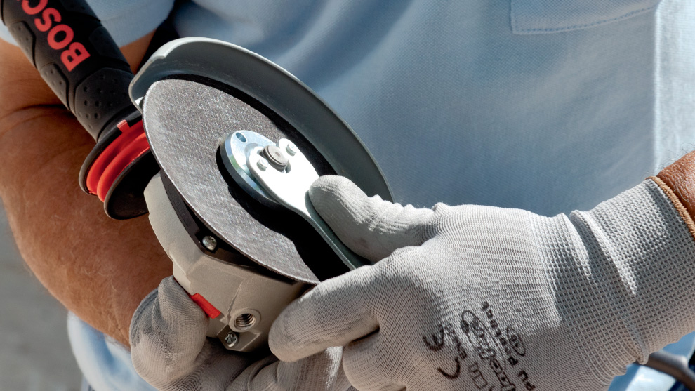 บุคคลหนึ่งถือเครื่องขัด Bosch Professional ไว้ในมือ.