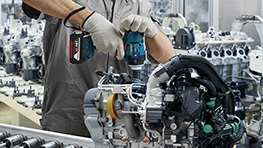 คนงานที่สวมหมวกนิรภัยและหน้ากากป้องกันกำลังใช้สว่านบนแบบหล่อ.