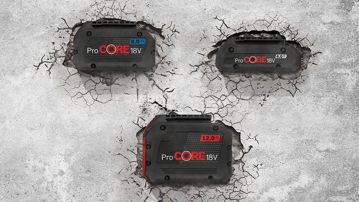 แบตเตอรี่ Bosch ProCORE 18V สามก้อนวางอยู่บนพื้นคอนกรีตที่แตกร้าว.