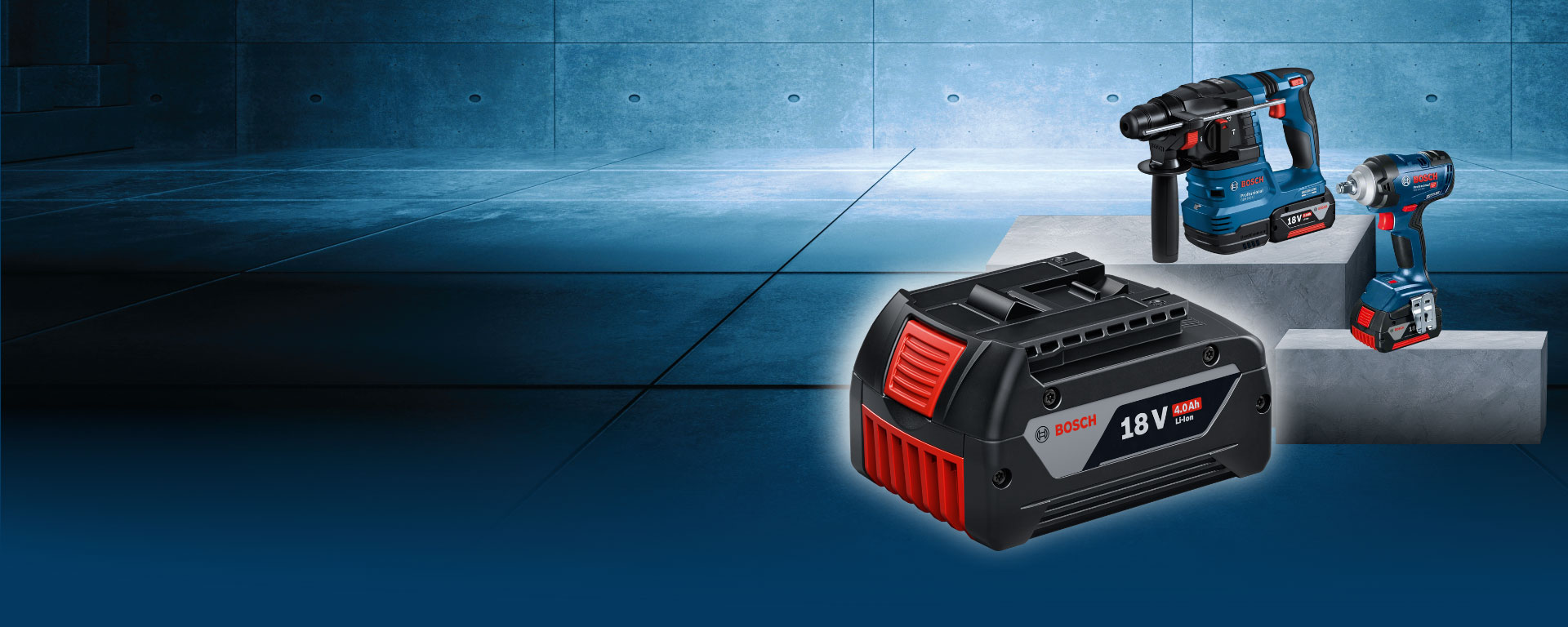 ภาพแสดงเครื่องมือ Bosch สามชิ้นบนพื้นคอนกรีตสีเทา: แบตเตอรี่, สว่าน และประแจไฟฟ้า.