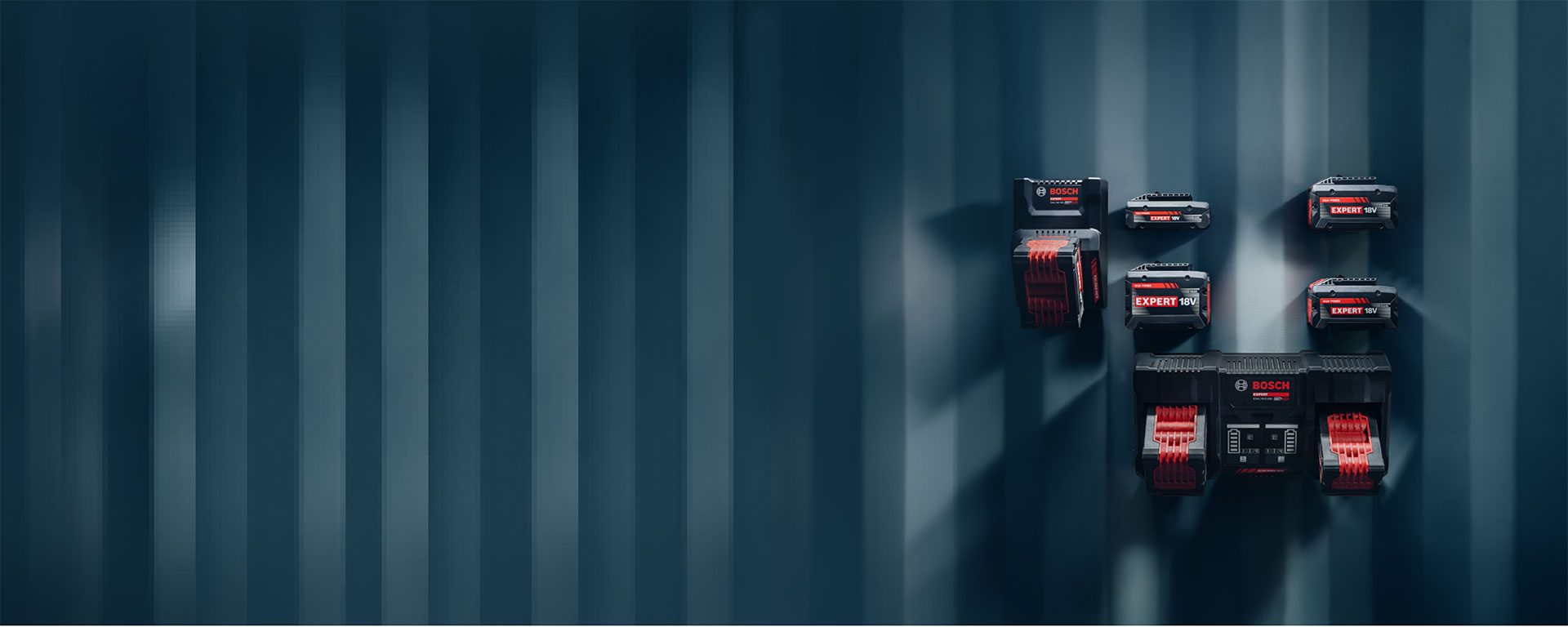แบตเตอรี่ Bosch Professional ที่แตกต่างกันติดตั้งอยู่บนผนังสีน้ำเงิน.