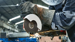 บุคคลหนึ่งกำลังตัดโลหะด้วยจานตัด Bosch Professional.