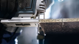 เลื่อยจิ๊กซอว์ Bosch Professional กำลังตัดผ่านแผ่นไม้.