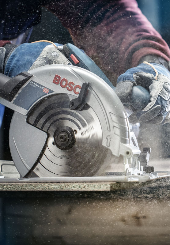 เลื่อยวงเดือน Bosch Professional ถูกใช้กับไม้ ฝุ่นฟุ้งกระจายขึ้น.