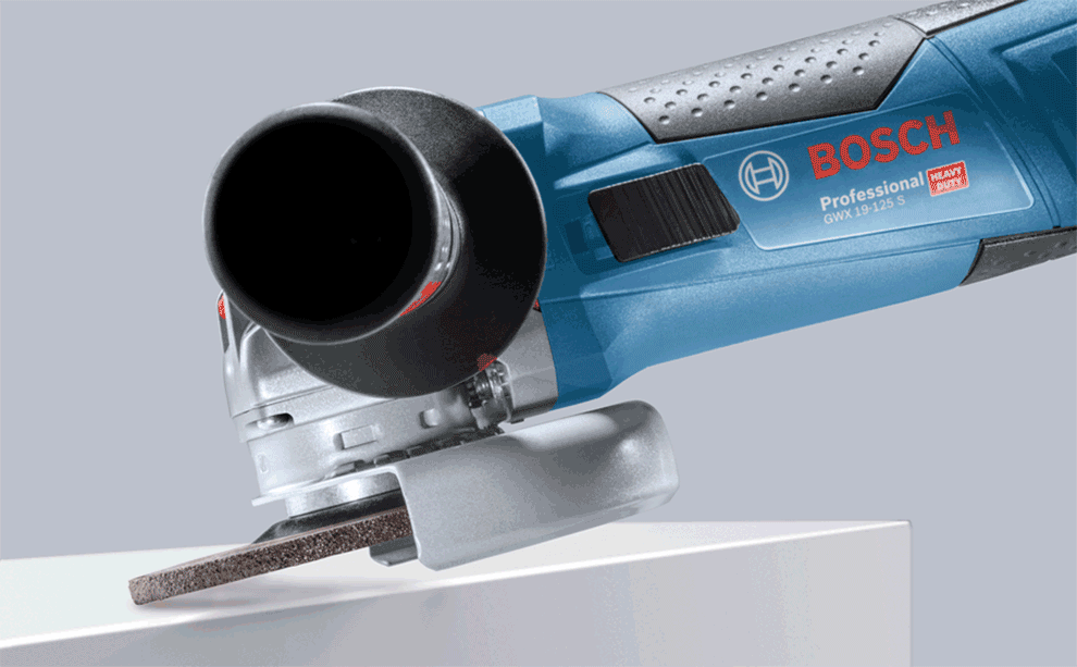 เครื่องเจียรมุมสีน้ำเงิน Bosch Professional กำลังตัดแผ่นไม้.